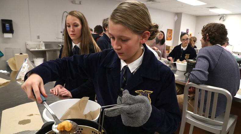 Lillian Weller and her classmates at the Global Impact STEM Academy experiment with different kinds of cooking oils in the food science lab as part of National Ag Day Thursday. BILL LACKEY/STAFF