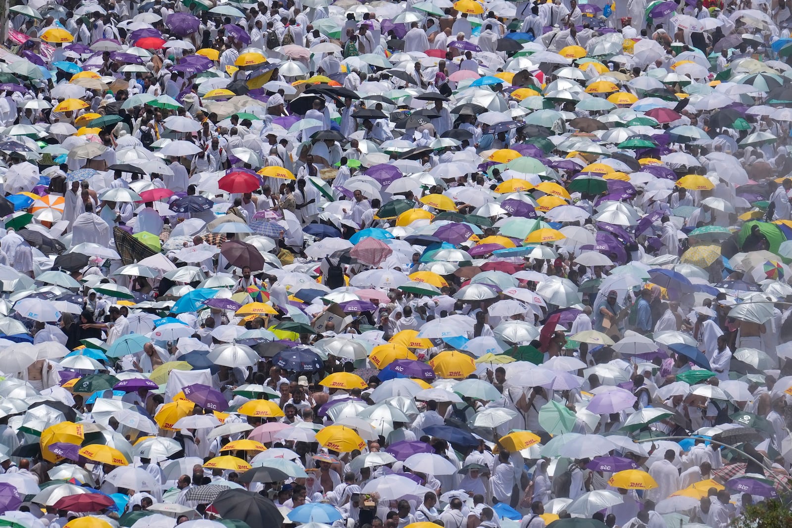 FILE - Muslim pilgrims use umbrellas to shield themselves from the sun as they gather outside Nimrah Mosque to offer the noon prayers in Arafat, on the second day of the annual hajj pilgrimage, near the holy city of Mecca, Saudi Arabia, Saturday, June 15, 2024. (AP Photo/Rafiq Maqbool, File)