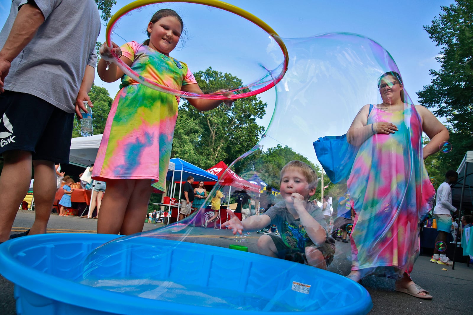 Wyatt Haugen tries to touch the giant bubble his sister, Kali, was creating with a hoola hoop Tuesday, August 6, 2024 during the National Night Out in Springfield. BILL LACKEY/STAFF