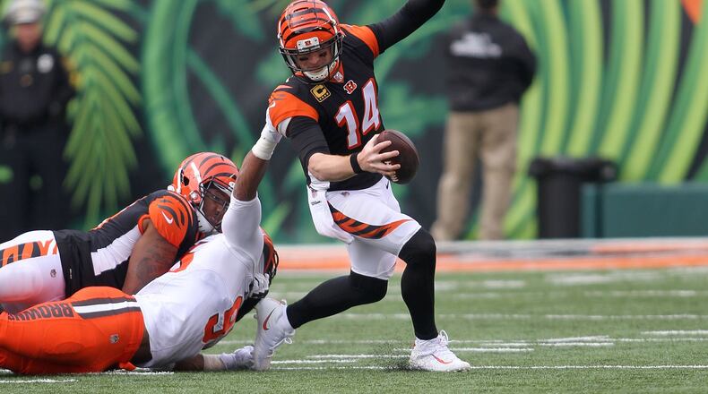 CINCINNATI, OH - NOVEMBER 25: Andy Dalton #14 of the Cincinnati Bengals slips out of an attempted tackle by Myles Garrett #95 of the Cleveland Browns during the second quarter at Paul Brown Stadium on November 25, 2018 in Cincinnati, Ohio. (Photo by John Grieshop/Getty Images)