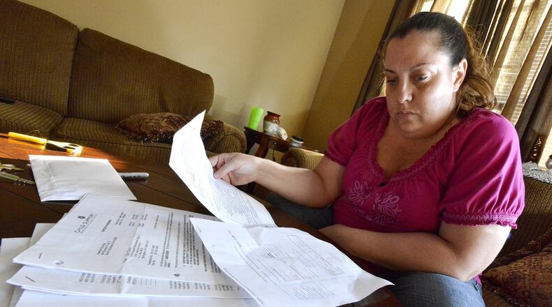 Heather Stuckey looks over some of the child support paperwork she’s received over the years as she’s tried to collect child support from her son’s father. Bill Lackey/Staff