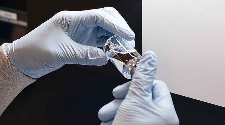 In this March 2020 photo provided by Gilead Sciences, a vial of the investigational drug remdesivir is visually inspected at a Gilead manufacturing site in the United States. Given through an IV, the medication is designed to interfere with an enzyme that reproduces viral genetic material. (Gilead Sciences via AP)