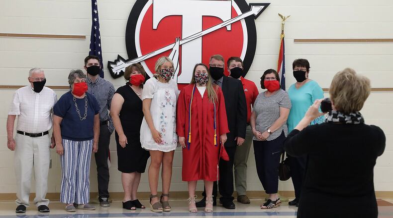 Tecumseh High School 2020 graduate Ellie Gehret, center, and her family pose for a picture with masks on during her individual graduation ceremony last year. BILL LACKEY/STAFF