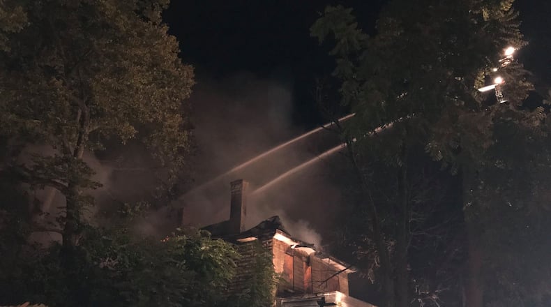 Springfield firefighters spray water on a home located on Yellow Springs Drive early Sunday morning.