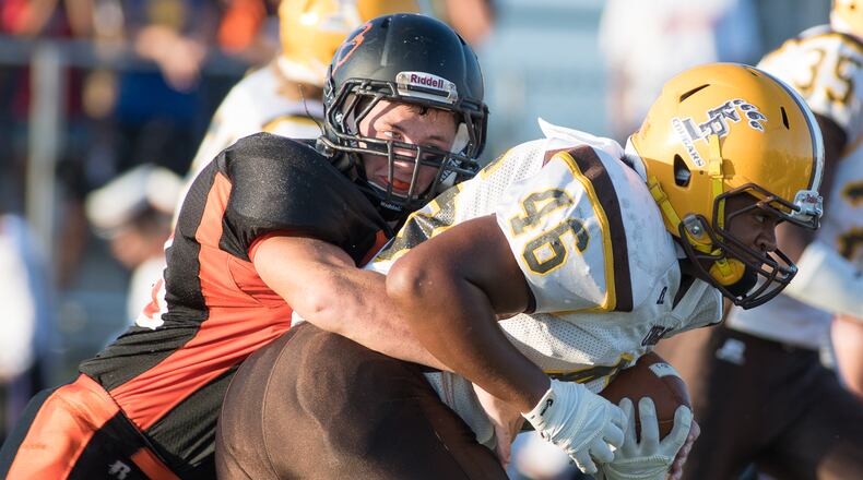 West Liberty-Salem’s Braden Miller (left) tackles Kenton Ridge’s Kobe Holtz (right) during a kickoff return in a nonconference game on Friday night. Bryant Billing/Contributor