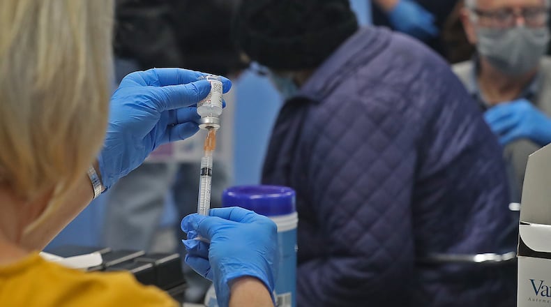 A dose of the COVID-19 vaccine is drawn up Wednesday at the Champaign County Government Center. BILL LACKEY/STAFF