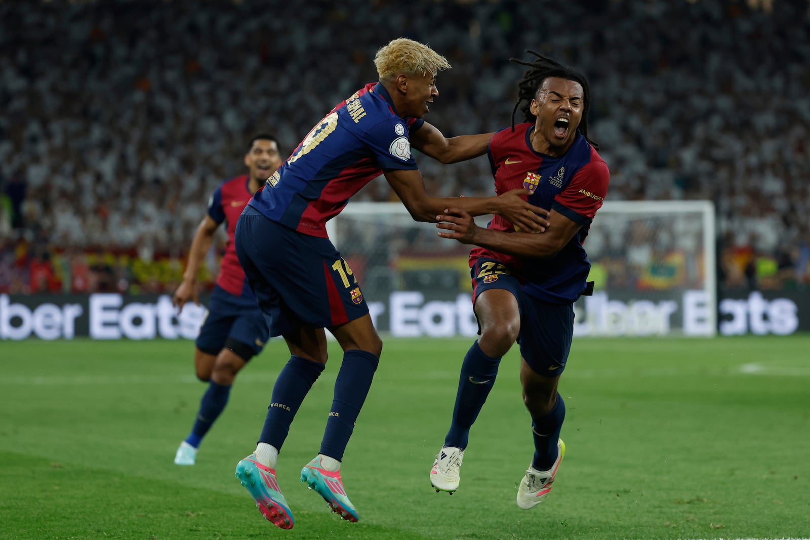 Barcelona's Jules Kounde, right, celebrates after scoring his side's third goal during the Spanish Copa del Rey final soccer match between Barcelona and Real Madrid at Estadio de La Cartuja stadium in Seville, Spain, Sunday, April 27, 2025. (AP Photo/Joan Monfort)