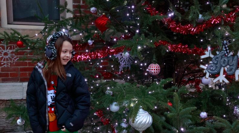 Neena Knox, 8, looks over the Christmas tree during the Christmas in South Charleston celebration Wednesday night, Dec. 7, 2022. The festivities included craft vendors, food trucks, a Cookie Walk along with a bonfire and a Christmas parade. Christmas in South Charleston was organized by the South Charleston Community Club. BILL LACKEY/STAFF
