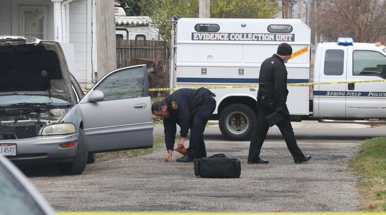 Springfield police collect evidence in an alley behind 1610 South Limestone Street Tuesday after a man was shot. STAFF/BILL LACKEY