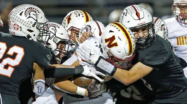 Northeastern's Cody Lookabaugh is tackled by Waynesville's Caleb Sullivan as he carries the ball up the middle during Friday's game in Waynesville. BILL LACKEY/STAFF