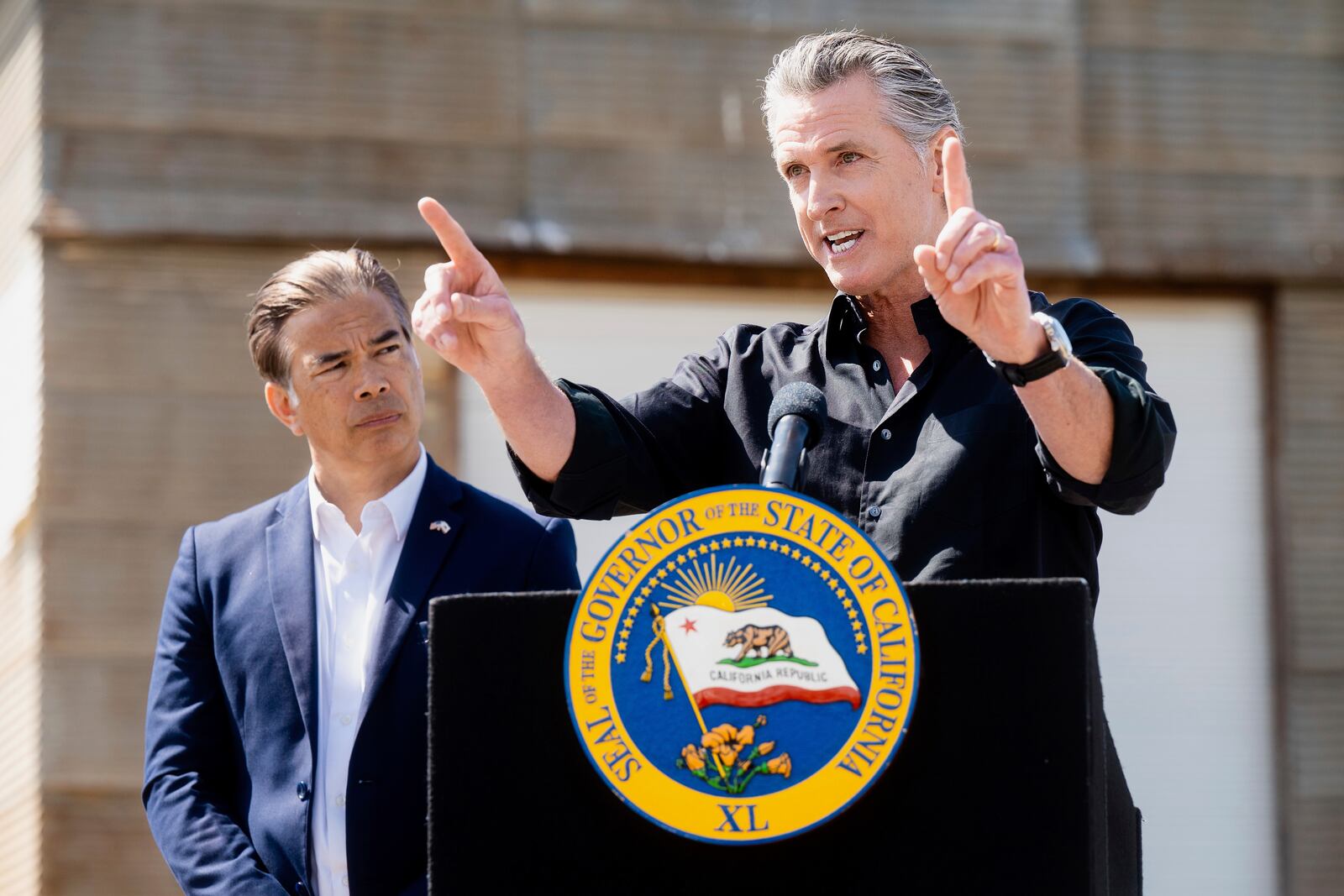 California Gov. Gavin Newsom discusses President Donald Trump's tariffs, as California Attorney General Rob Bonta, left, listens, during a press conference on Wednesday, April 16, 2025, at an almond farm in Ceres, Calif. (AP Photo/Noah Berger)