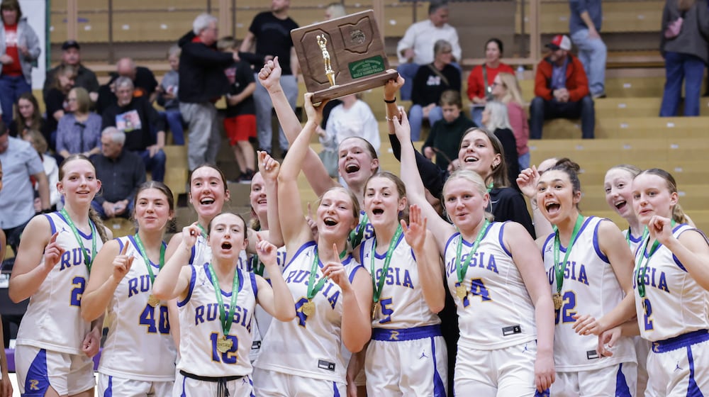 Russia players celebrate with a Division VII regional championship trophy after beating Cedarville 40-32 on Saturday, March 7 at Vandalia-Butler's Student Activity Center. The Raiders captured the program's first regional title. BRYANT BILLING / STAFF