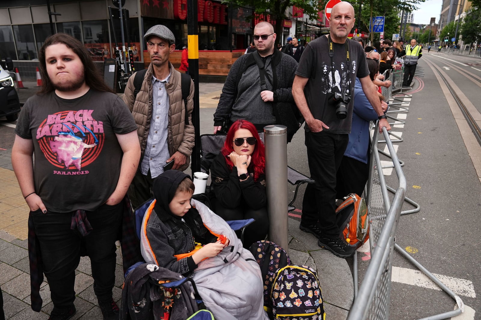 Fans gather near the Black Sabbath Bridge bench on Broad Street ahead of the funeral procession for Black Sabbath frontman Ozzy Osbourne, in Birmingham, England, Wednesday July 30, 2025. (Jacob King/PA via AP)