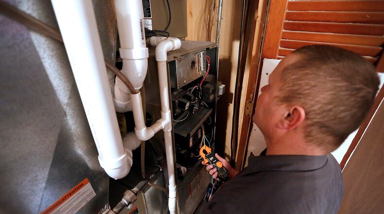 Shayne Houseman, a technician Hauck Bros. Heating and Cooling, services a customer’s natural gas furnace. Bill Lackey/Staff