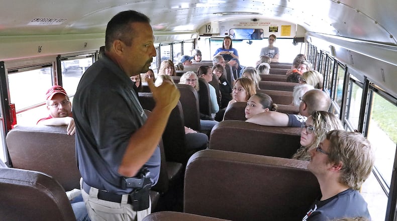Springfield City School District Safety and Security Coordinator David Lyle talks to a group of bus drivers from throughout Clark County about a shooting scenario they just went over on a bus Monday at Indian Valley School. Bill Lackey/Staff