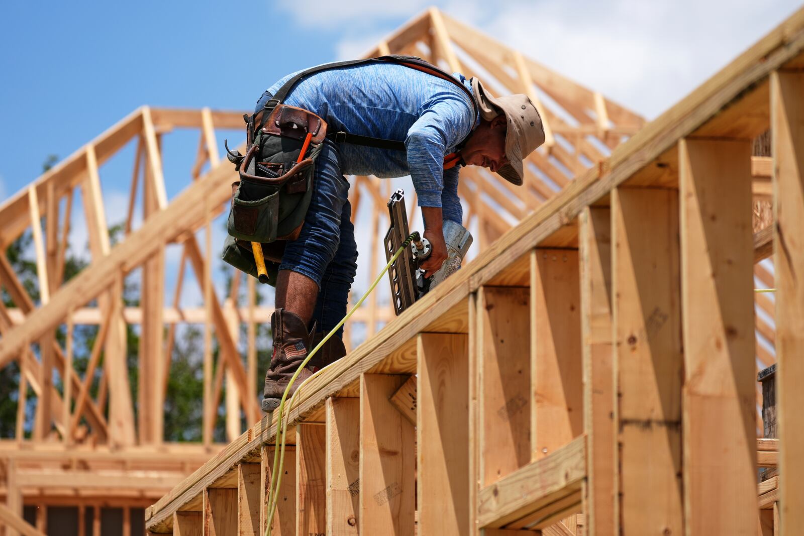 A worker works on the roofing structure of new home under construction, Tuesday, July 15, 2025, in Richardson, Texas. (AP Photo/Tony Gutierrez)