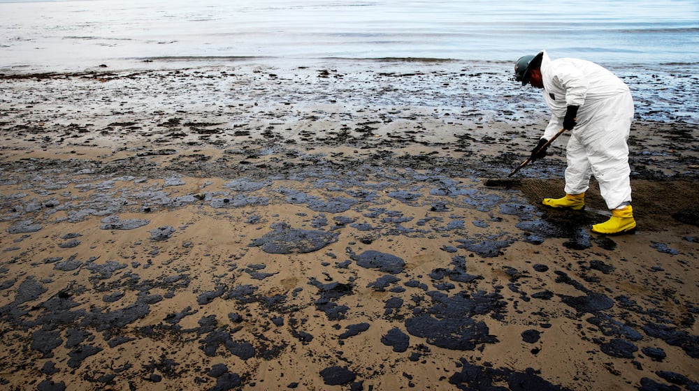 FILE - A worker removes oil from sand at Refugio State Beach, north of Goleta, Calif., on May 21, 2015. (AP Photo/Jae C. Hong, File, File)