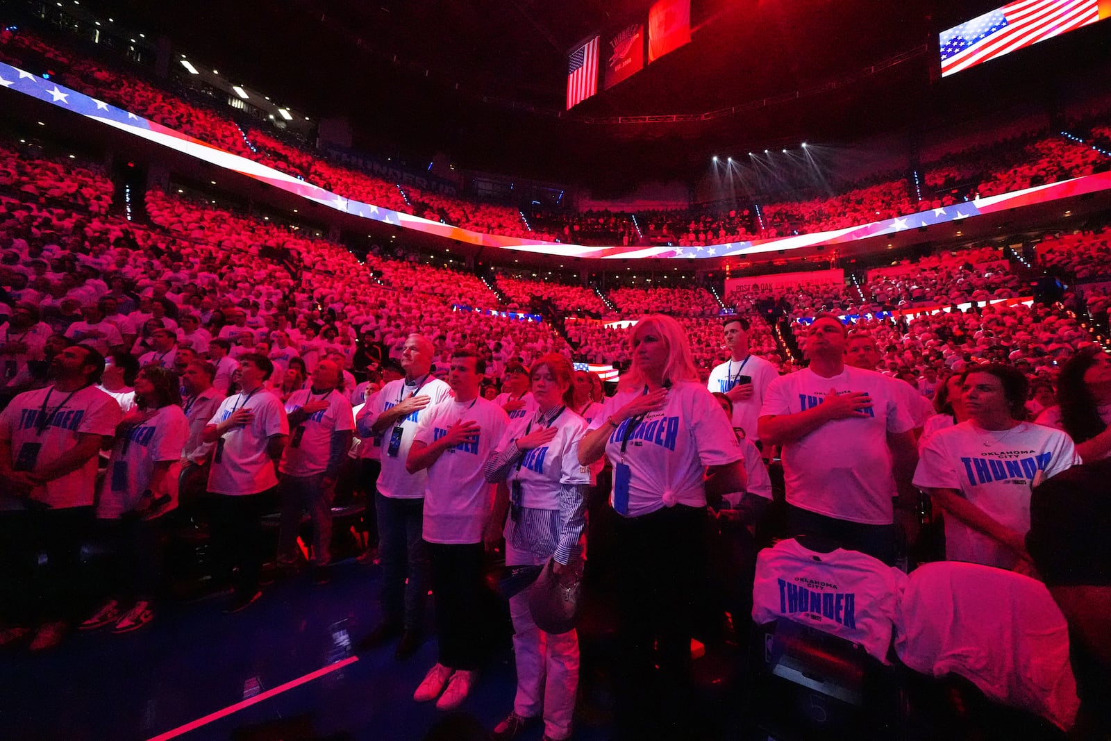 Fans listen as the national anthem plays before Game 1 of the NBA Finals basketball series between the Indiana Pacers and the Oklahoma City Thunder Thursday, June 5, 2025, in Oklahoma City. (AP Photo/Julio Cortez)