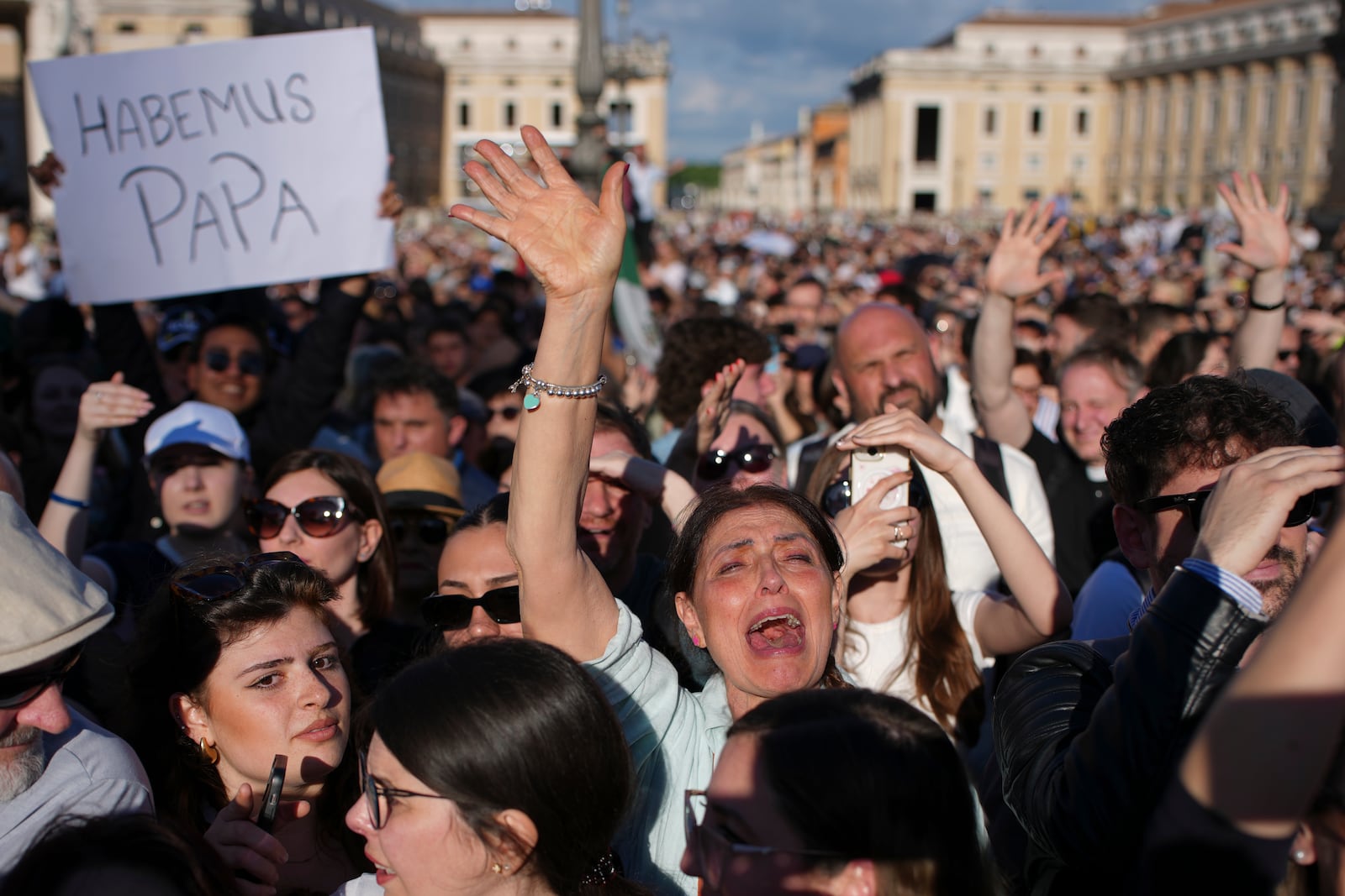 Faithful celebrate after white smoke appeared from the chimney of the Sistine Chapel where 133 cardinals gathered on the second day of the conclave to elect a successor to late Pope Francis, at the Vatican, Thursday, May 8, 2025. (AP Photo/Emilio Morenatti)