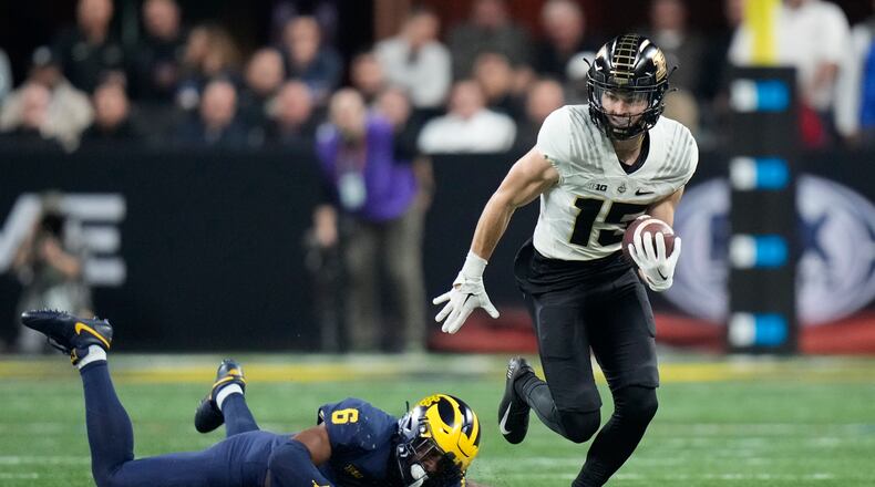 Purdue wide receiver Charlie Jones (15) runs with the ball past Michigan defensive back R.J. Moten during the first half of the Big Ten championship NCAA college football game, Saturday, Dec. 3, 2022, in Indianapolis. (AP Photo/AJ Mast)