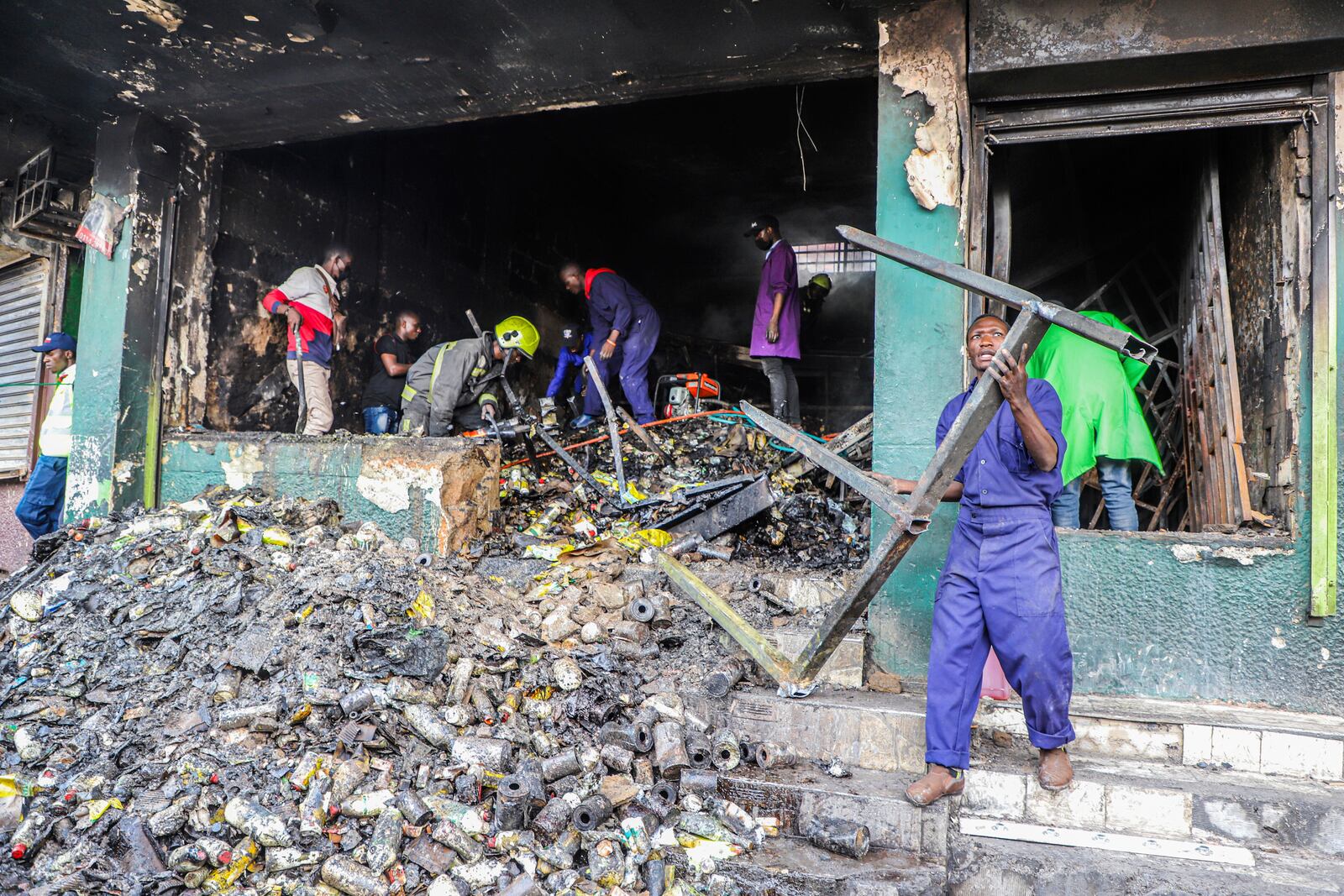 Business owners assess the damage to their vandalized merchandise and shop, in the one-year anniversary of a deadly anti-tax demonstration in Nairobi, Kenya, Thursday, June 26, 2025. (AP Photo/Patrick Ngugi)