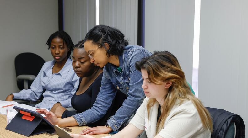Junior Guerlancia M. Notis, far left, senior Taisha Louis, and senior Peri Hillerfreund, right, all of Springfield High School, listen as Kaitlyn Tyler, education coordinator for Greater Springfield Partnership, shows them different websites to use to find jobs during Magnify Internship Training Day through the Greater Springfield Partnership. JOSEPH COOKE/STAFF
