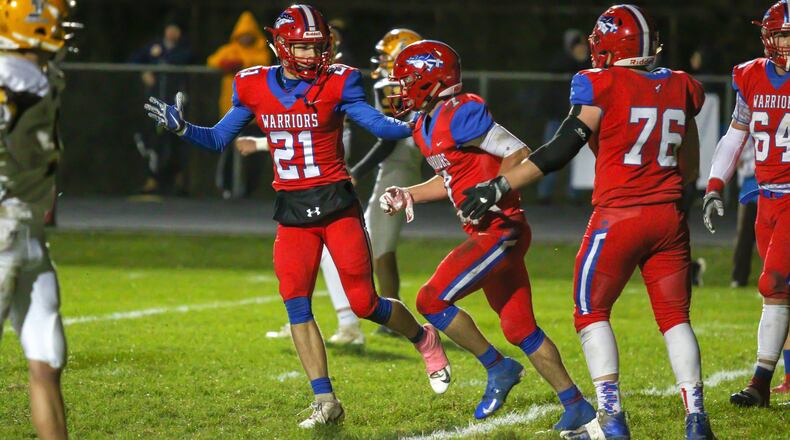 Northwestern High School senior Landon Burns (21) celebrates a touchdown with senior Eli Berner (7) during the Warriors 21-14 victory over Kenton Ridge on Oct. 19. The Warriors will travel to Cincinnati Wyoming for its first-ever football playoff game on Saturday. CONTRIBUTED PHOTO/MICHAEL COOPER