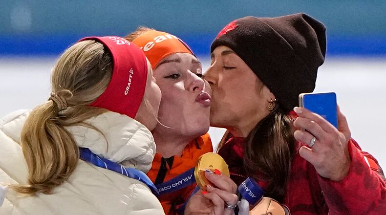 Antoinette Rijpma-de Jong of the Netherlands, center and gold medal, Ragne Wiklund of Norway, left and silver medal, and Valerie Maltais of Canada, right and bronze medal, celebrate on the podium of the women's 1500 meters speedskating race at the 2026 Winter Olympics, in Milan, Italy, Friday, Feb. 20, 2026. (AP Photo/Ben Curtis)