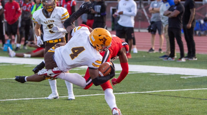 Alter's Rod Owens dives into the end zone over Trotwood-Madison's Darius Dennis early in the second quarter Thursday night in Trotwood. Jeff Gilbert/CONTRIBUTED