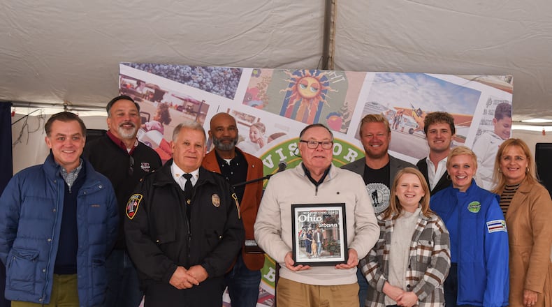 The City of Urbana was named Best Hometown by Ohio Magazine. To celebrate this achievement, the Champaign County Chamber of Commerce & Visitors Bureau held a special ceremony on Second Saturday, Nov. 9, in downtown Urbana. Front row, from left to right: Editor of Ohio Magazine Jim Vickers, police Chief Matt Lingrell, Mayor Bill Bean, Chamber Director Sara Neer, Visitors Representative Polly Trenor, Director of GrandWorks Stacy Weller. Back row, left to right: Urbana City School Superintendent Charles Thiel, Kalen Howell Sr. Jamon Sellman and Justin Weller. Contributed/Tammi Feehan for Urbana Tomorrow.