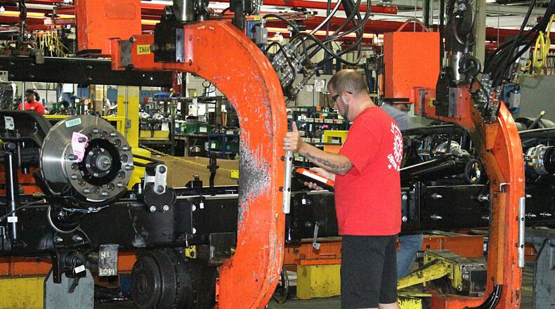 A Navistar International employee gets ready to flip a truck chassie on the assembly line in September. JEFF GUERINI/STAFF