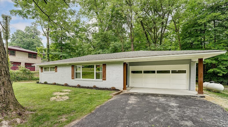The front of the rehabbed brick ranch home features a covered garage and front entry, asphalt driveway and new landscaping. CONTRIBUTED PHOTOS