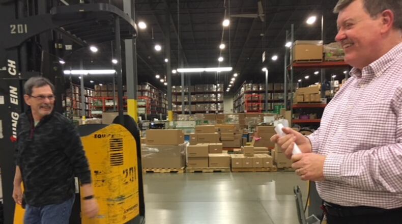 James Dromey, Jr., right, American Honda Motor Co. senior manager, procurement and logistics, shared a laugh in April with a worker at Honda’s Midwest Consolidation Center in Troy. The Honda centers in Troy are key parts of the company’s national parts distribution network. THOMAS GNAU/STAFF