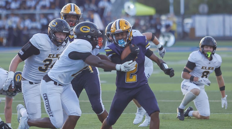 Springfield's Sherrod Lay Jr. (#2) runs with the ball as Centerville's Mason Boykin (#11) tries to tackle him during a game on Friday, September 19, 2025, at Springfield High School. JOSEPH COOKE/STAFF