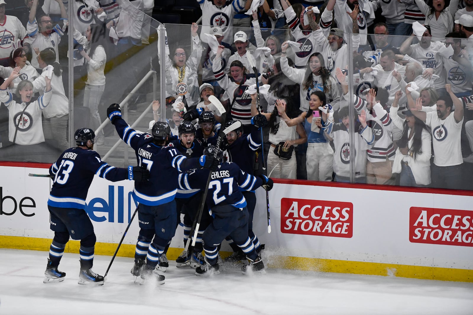 Winnipeg Jets' Cole Perfetti (91) celebrates after his goal with teammates to tie the St. Louis Blues during during the third period of Game 7 in an NHL hockey first-round playoff series in Winnipeg, Manitoba, Sunday, May 4, 2025. (Fred Greenslade/The Canadian Press via AP)