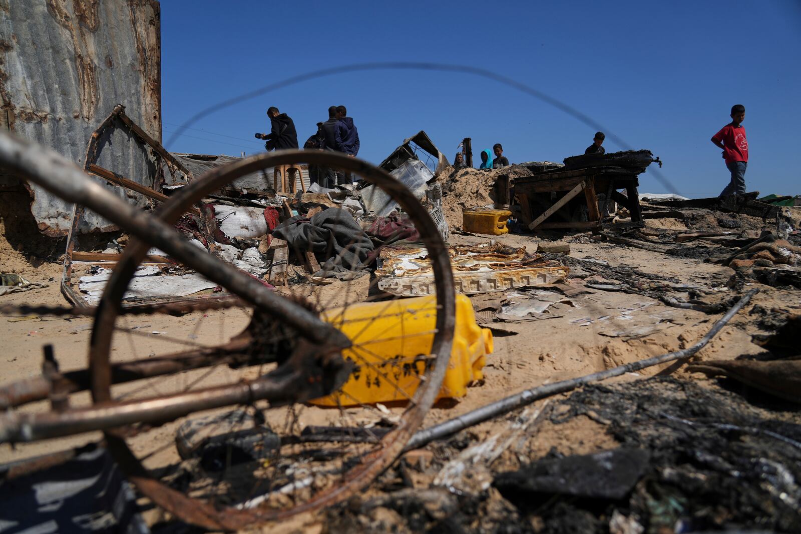 Palestinians inspect the remains of a displacement tent hit by an Israeli airstrike overnight, killing 10 members of the Abu Al-Rous family, in Khan Younis, southern Gaza Strip, Thursday, April 17, 2025. (AP Photo/Abdel Kareem Hana)