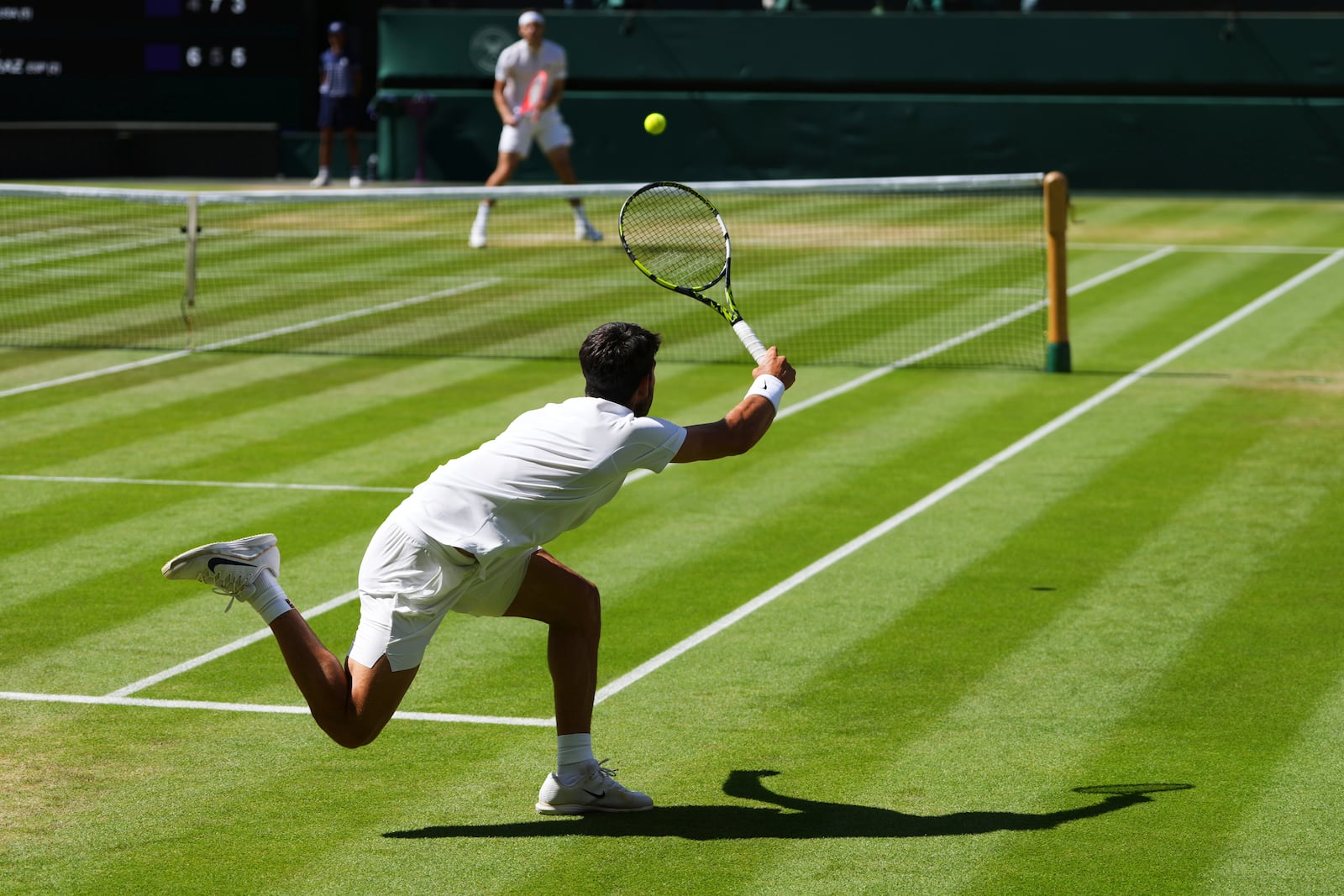 Carlos Alcaraz of Spain returns the ball to Taylor Fritz of the U.S. during the men's semifinal singles match at the Wimbledon Tennis Championships in London, Friday, July 11, 2025.(AP Photo/Kirsty Wigglesworth)