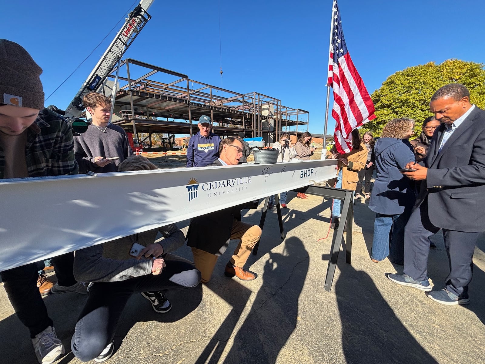 Dr. Robert Clark takes time to sign his name to the beam during Cedarville University's beam topping celebration. Contributed
