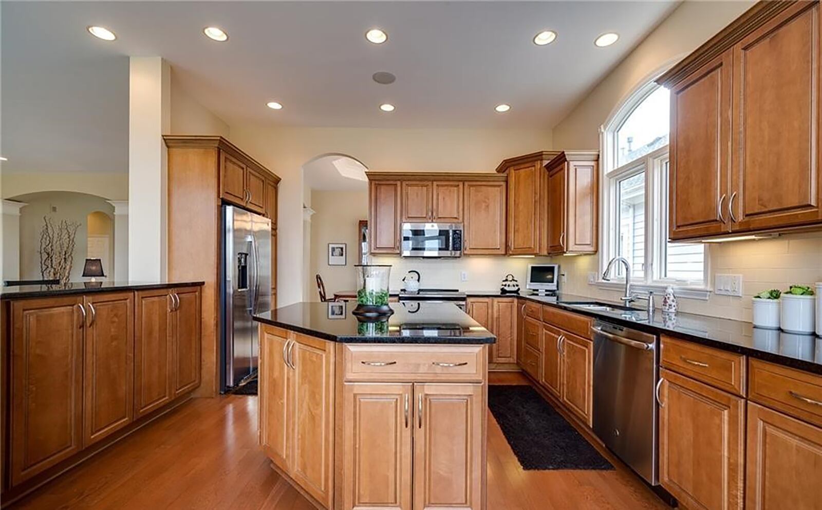 The kitchen has wood cabinets, wood floors, a breakfast bar and island and granite countertops. Appliances include a conduction range.