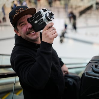 Jordan Heid uses an old film camera as he arrives for his flight at the Nashville International Airport, Tuesday, Nov. 25, 2025, in Nashville, Tenn. (AP Photo/George Walker IV)