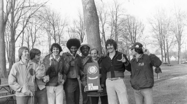 Wittenberg’s Larry Hunter holds the 1977 national championship photo and poses for a photo with players, including Brian Agler, far left, in Springfield. Wittenberg photo