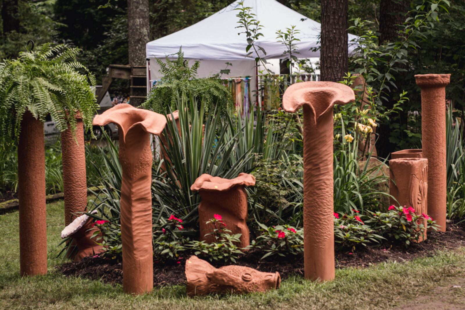 Art sculptures created from local clay are a unique artistic feature that are scattered throughout the flower gardens. The sculptures are lighthearted in design to help visitors laugh and have fun while touring the gardens.  Photo by Elizabeth Nihiser.