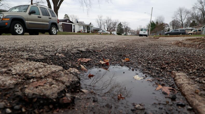 A water filled pothole along Fenwick Avenue in New Carlisle Friday, Dec. 9, 2022. BILL LACKEY/STAFF