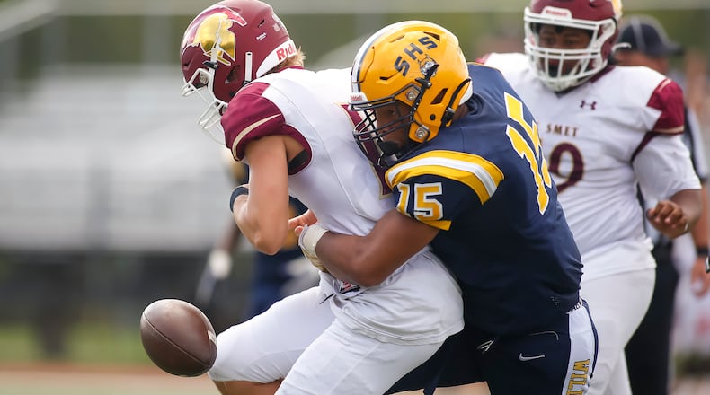 Springfield High School defensive end Jackson Heims rips the ball away from a St. Louis De Smet Jesuit player during their Week 2 game last season at Brebeuf Jesuit Preparatory School in Indianapolis. Heims was one of several area players to pick up new scholarship offers last week. Michael Cooper/CONTRIBUTED