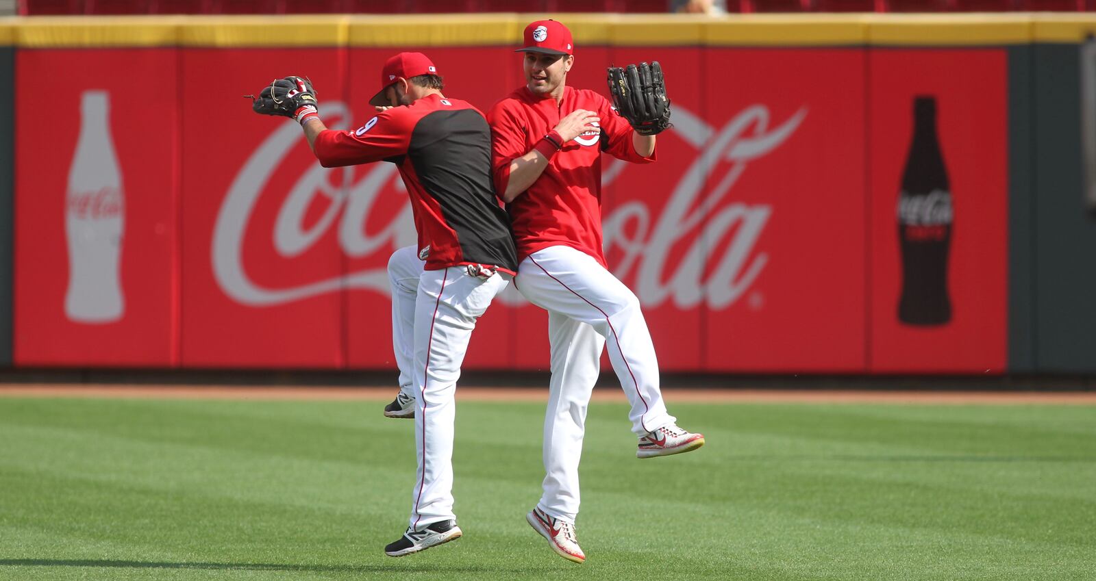 The Reds' Jose Peraza, left, bumps hips with Jesse Winker during batting practice on Friday, April 14, 2017, at Great American Ball Park in Cincinnati. David Jablonski/Staff