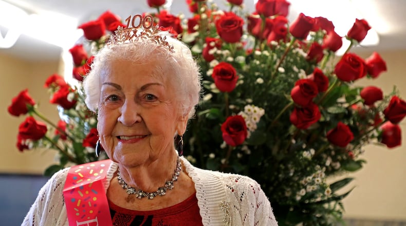Clara Belle Haynes looks over the 100 roses she received from the Jackson, Lytle and Lewis Life Celebration Center for her 100th birthday during a party in her honor Friday at the Northwood Assisted Living Center Thurday. Clara Belle, who actually turns 100 on Saturday, was born on a leap year and while she’s 100 years old she’s only had 25 actual birthdays. BILL LACKEY/STAFF