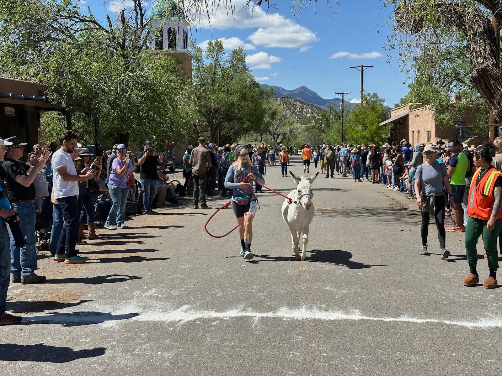 Pack burros and their human companions race through the streets of a former mining town and across backcountry desert trails in Cerrillos, N.M., on Saturday, May 3, 2025. (AP Photo/Morgan Lee)
