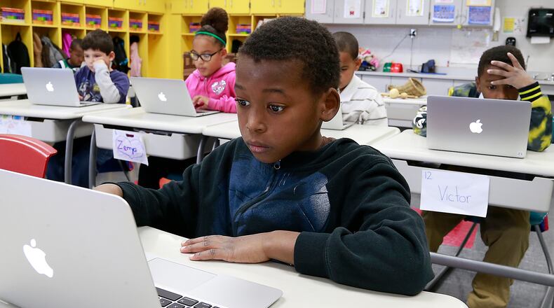 Anthony Marshall and his third grade classmates work on their labtop computers in class Friday. Bill Lackey/Staff