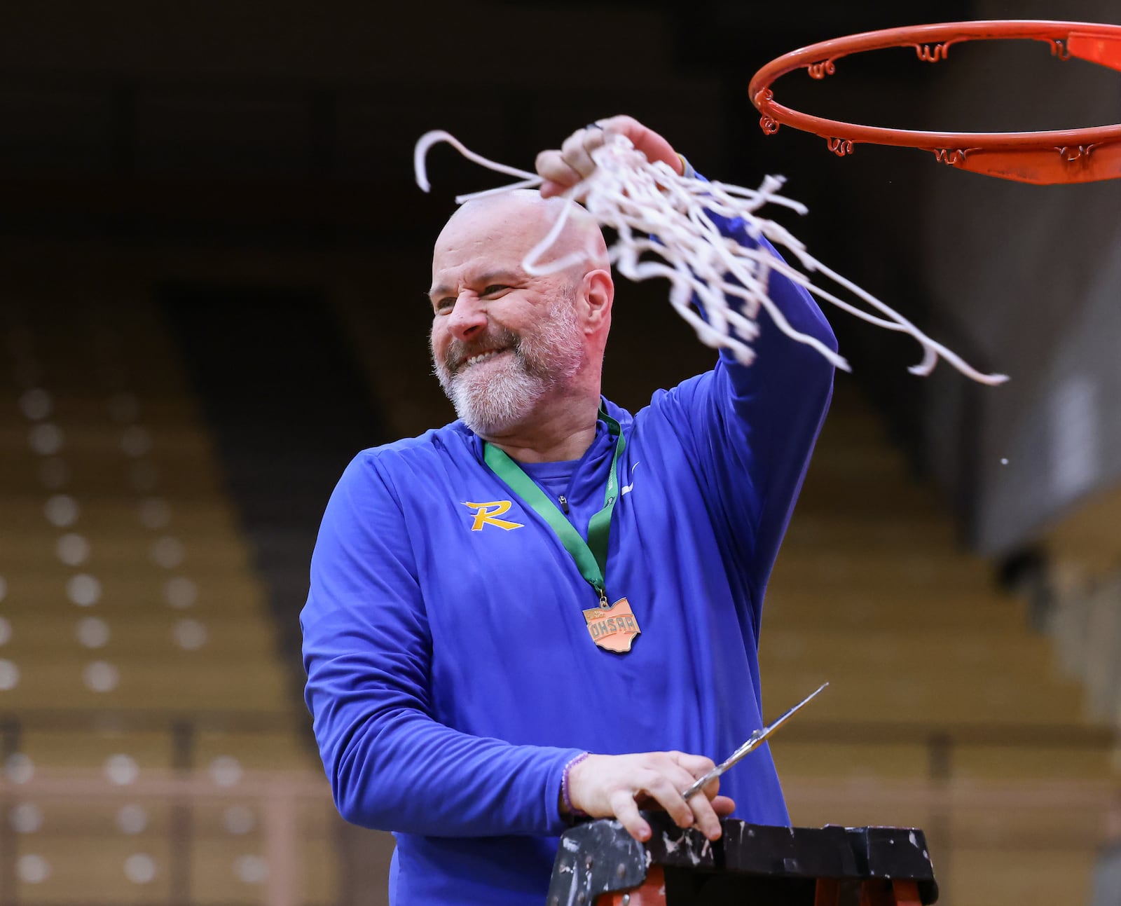 Russia coach Mike Bashore twirls the net after cutting it down following a 40-32 win over Cedarville in a Division VII regional final on Saturday, March 7 at Vandalia-Butler's Student Activity Center. Bashore is in his third season. BRYANT BILLING / STAFF
