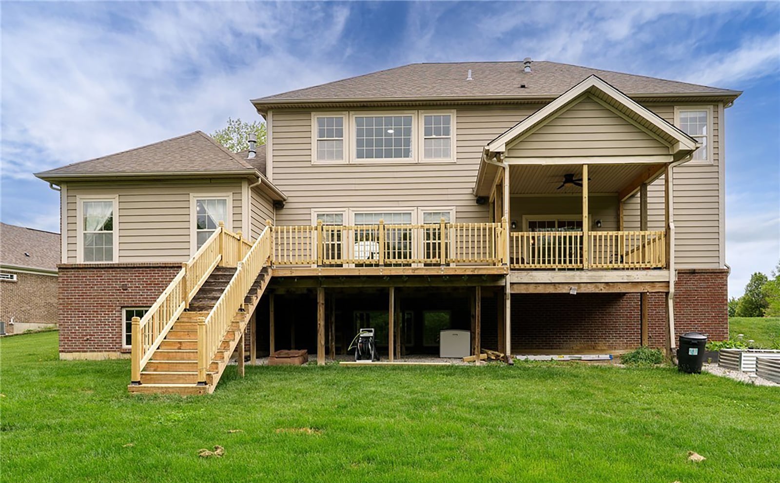 The back of the home has a partially covered deck with wood railings. There is an enclosed storage area below the deck. CONTRIBUTED